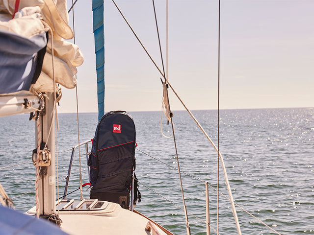  A Red backpack on the edge of a sailing boat in the ocean